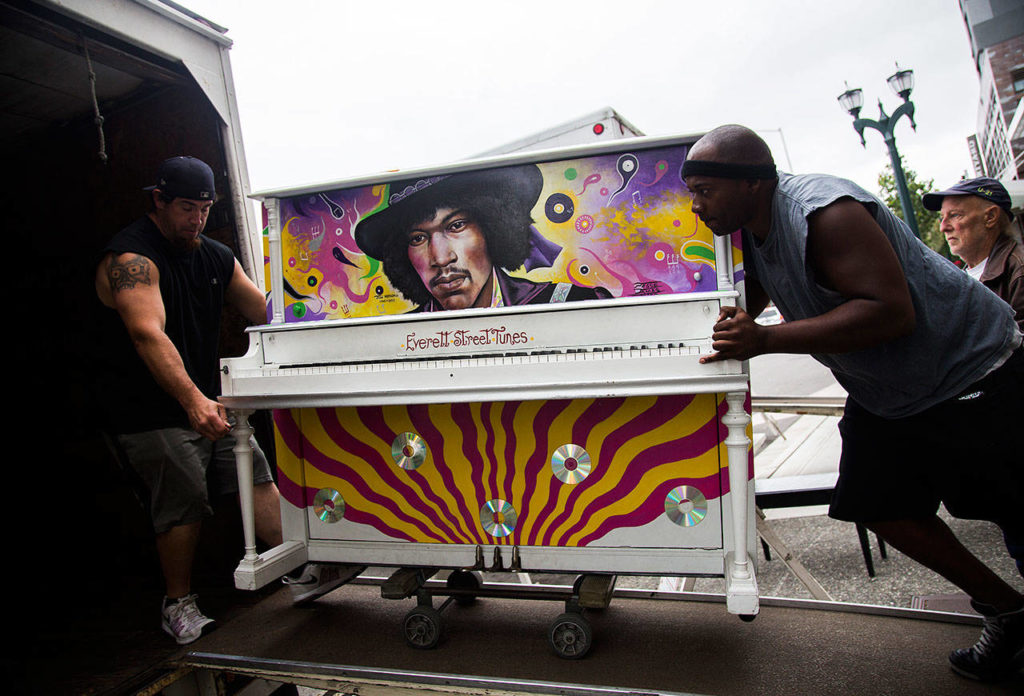 Brian Walsh (left) and Alton Johnson of Piano and Organ Moving Co. Inc. move the Jimi Hendrix Experience piano into their moving van on Aug. 1. (Olivia Vanni / The Herald)
