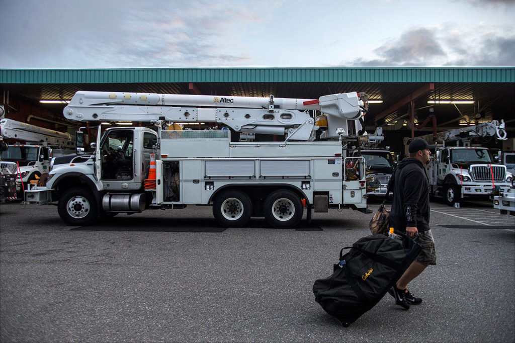 A Snohomish County PUD worker walks his bags to his utility truck at the Snohomish County Public Utility District’s Operations Center on Thursday in Everett. (Olivia Vanni / The Herald)

