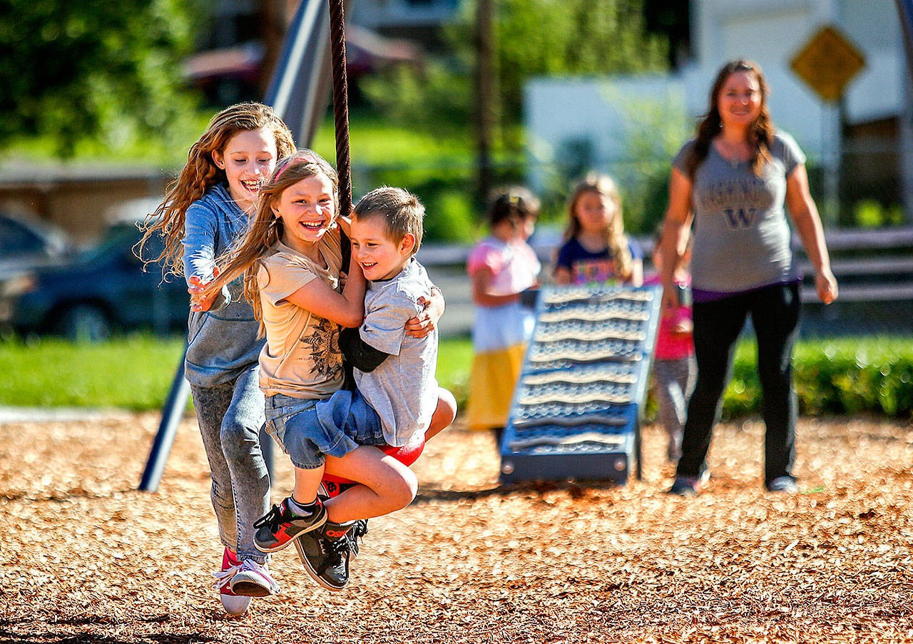 Chased by her friend and neighbor, Layla Taylor, 11 (left) Amberle Peterson, 10, and her brother, Noah, 4, fly through the air on a zip line as their mom, Brandy Peterson watches at Henry M. Jackson Park, in August, 2016. A state grant provided some of the funding for improvements at the park. (Dan Bates / Herald file photo)