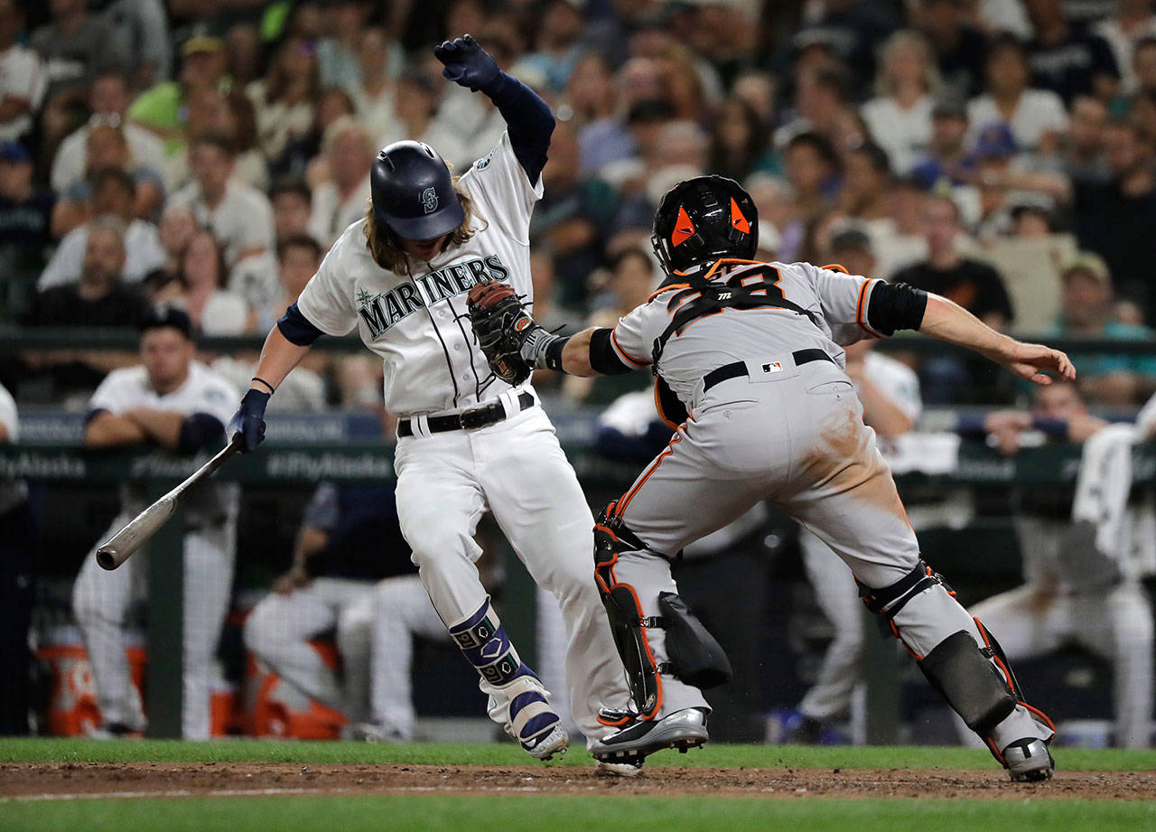 Seattle’s Ben Gamel avoids a tag on a dropped third strike by San Francisco’s Buster Posey during the eighth inning of a July 24 game at Safeco Field. (AP Photo/Ted S. Warren)