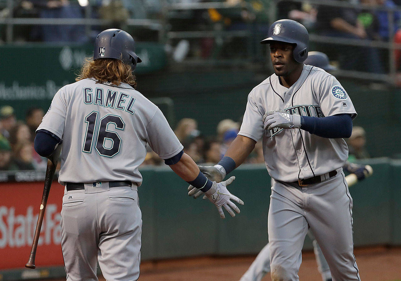 The Mariners’ Guillermo Heredia (right) is congratulated bt Ben Gamel after scoring against the Athletics during the fourth inning of a game on May 23, 2018, in Oakland, Calif. (AP Photo/Jeff Chiu)