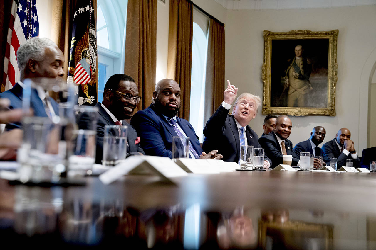 President Donald Trump points up to heaven as he speaks during a meeting with inner city pastors in the Cabinet Room of the White House in Washington on Wednesday. (AP Photo/Andrew Harnik)