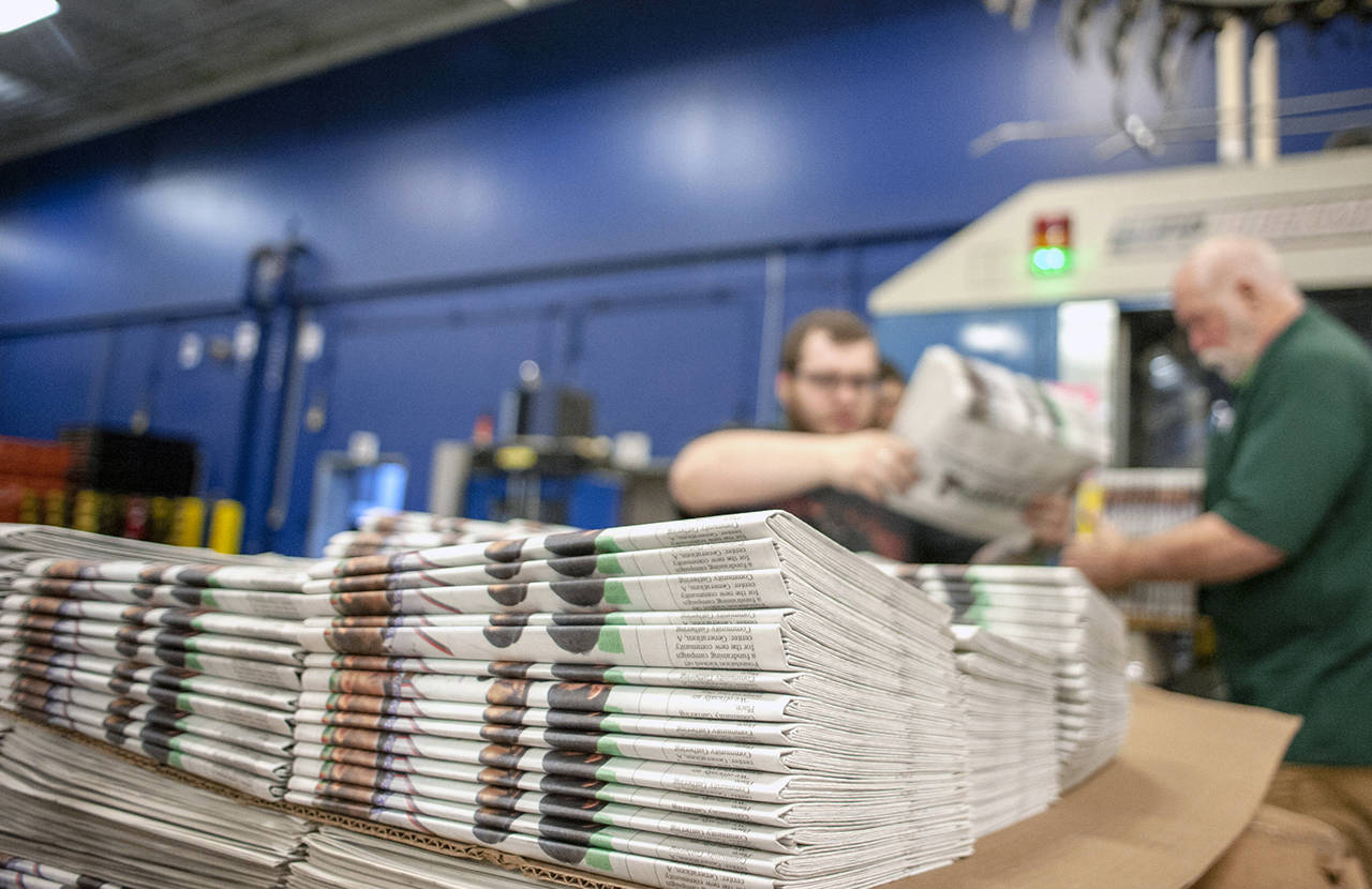 In this April 11 photo, production workers stack newspapers onto a cart at the Janesville Gazette Printing & Distribution plant in Janesville, Wisconsin. (Angela Major/The Janesville Gazette via AP, File)
