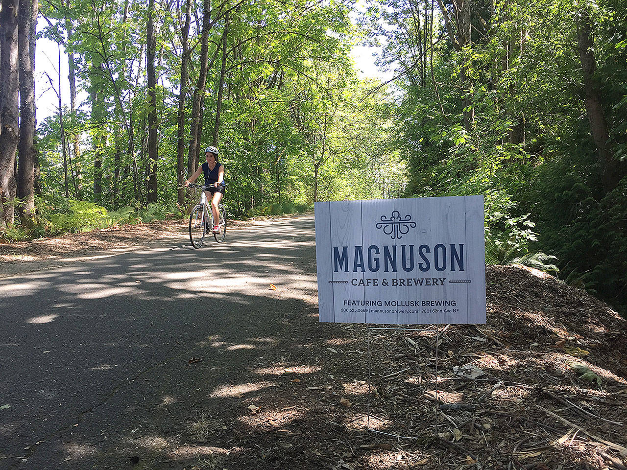 Signs advertise the new Magnuson Cafe & Brewery on the Burke-Gilman Trail. (Aaron Swaney)