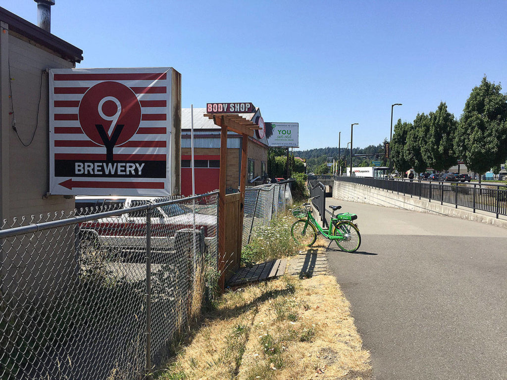 A rental bike is parked in front of Kenmore’s 9 Yards Brewing along the Burke-Gilman Trail. (Aaron Swaney)
