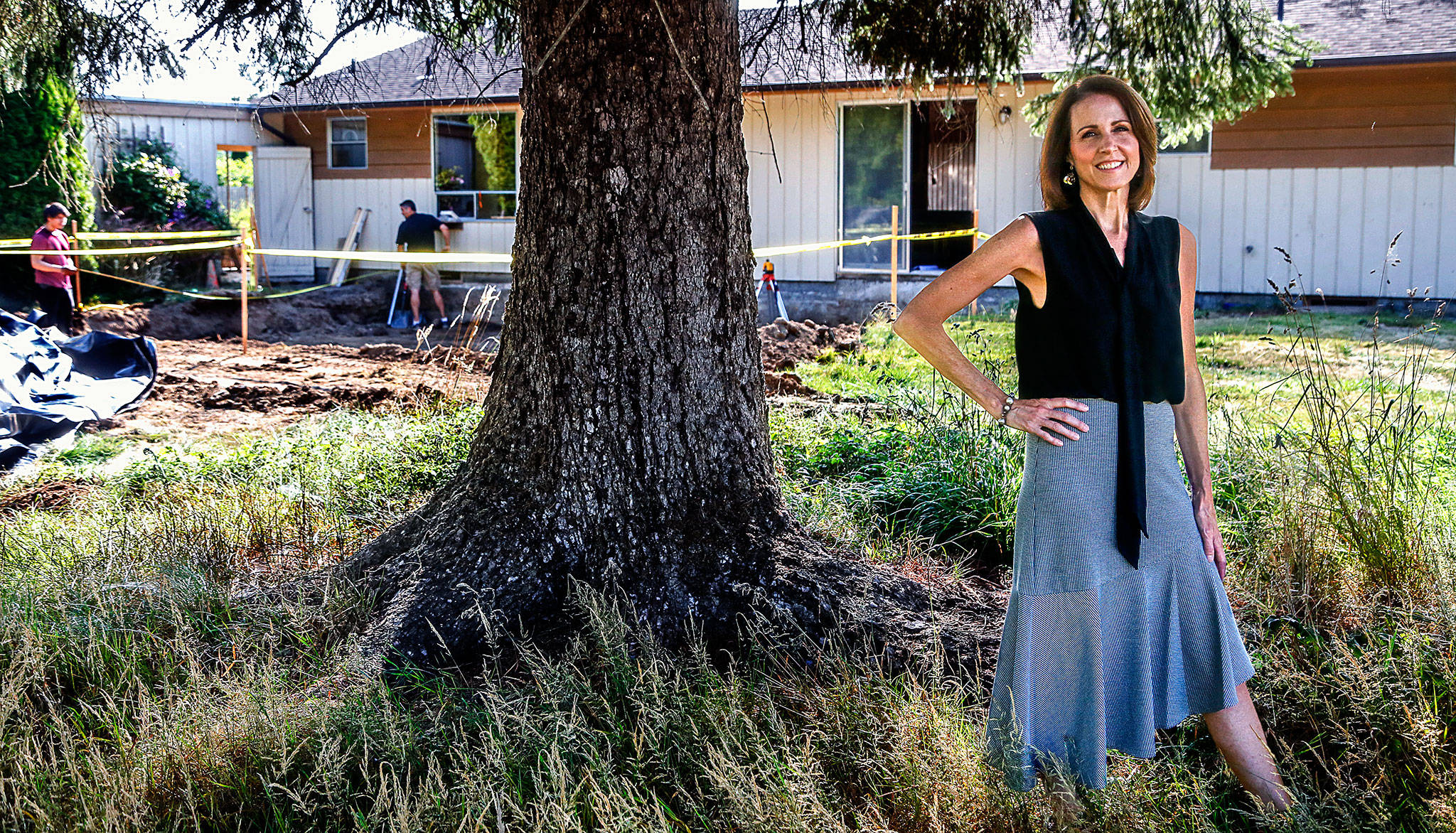 Tracy Rubstello, director of development for the Bridge Receiving Center (background), talks about the home being created as a 30-day refuge for children who are first entering foster care. (Dan Bates / The Herald)