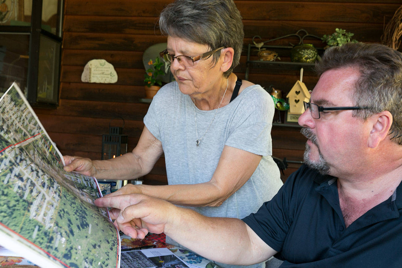 Susan Fenner (left) and Stacy Brewer look over a map of a proposed annexation to the city of Lake Stevens Sunday afternoon on Aug 5, 2018. (Kevin Clark / The Herald)