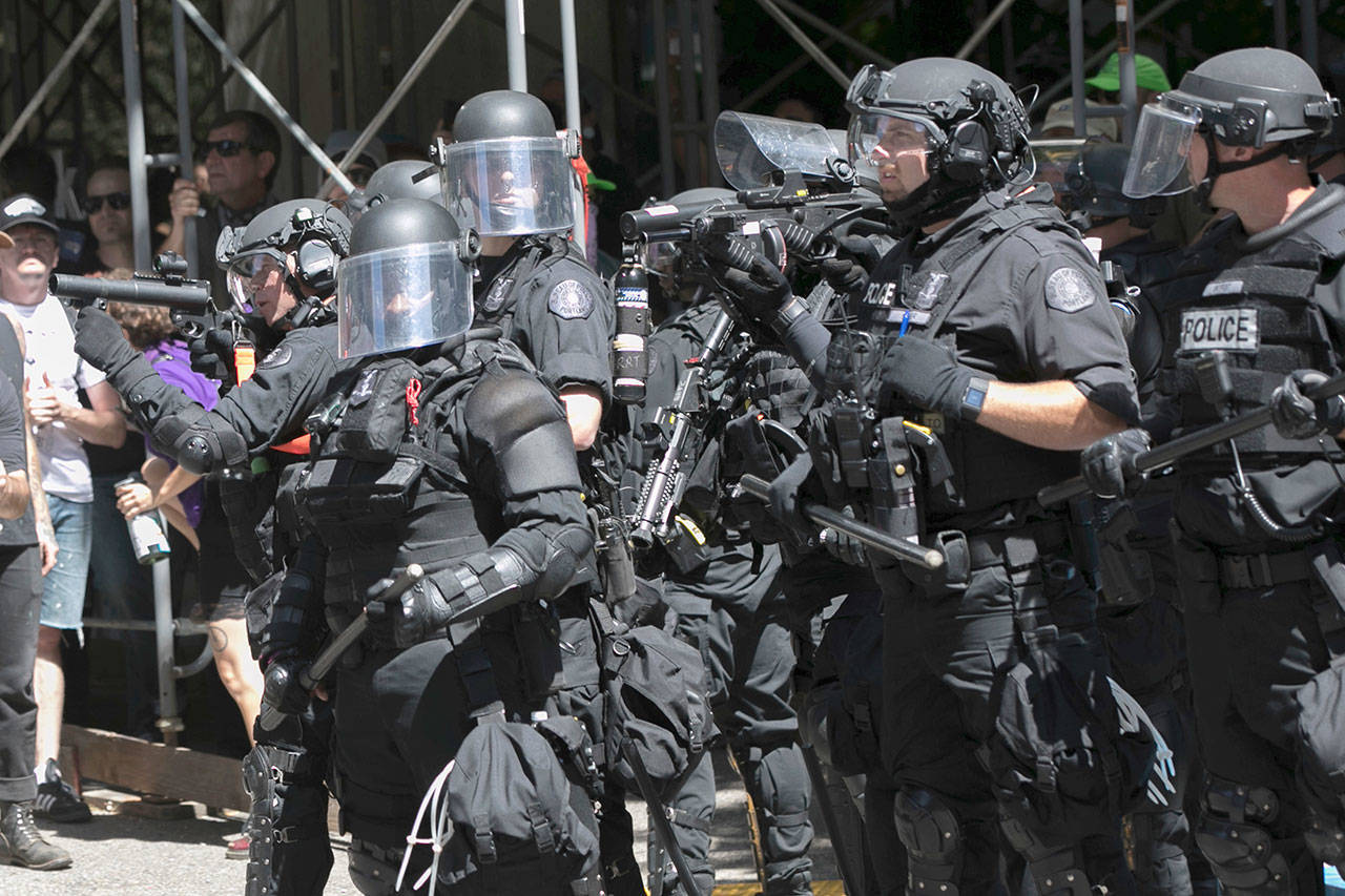Police deploy flash bang grenades during a rally in Portland on Saturday. Small scuffles broke out as police deployed “flash bang” devices and other means to disperse hundreds of right-wing and self-described anti-fascist protesters. (John Rudoff / Associated Press)