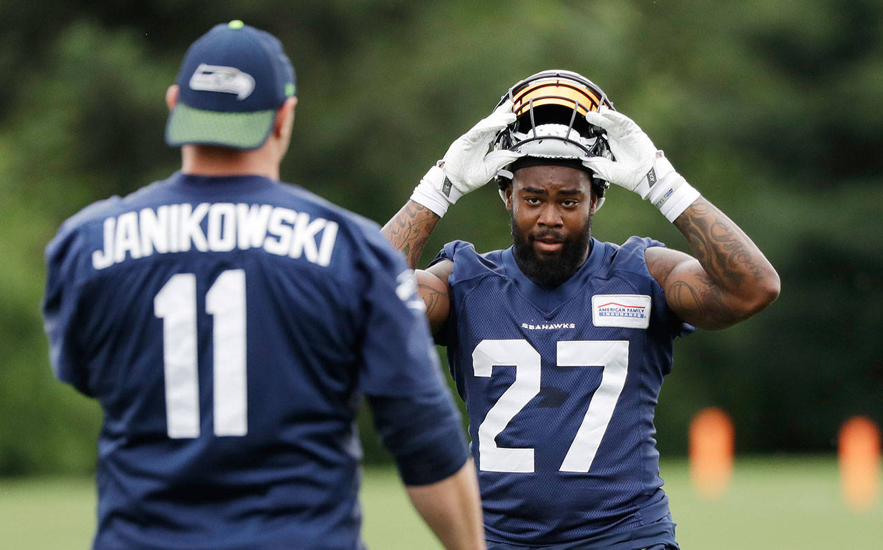 Seahawks running back Mike Davis (27) turns to kicker Sebastian Janikowski during a practice on June 7, 2018, in Renton. (AP Photo/Elaine Thompson)