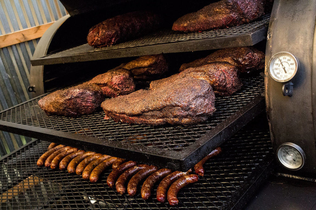 Brisket, prime rib and sausages are cooked in a smoker affectionately named Bertha. (Andy Bronson / The Herald)
