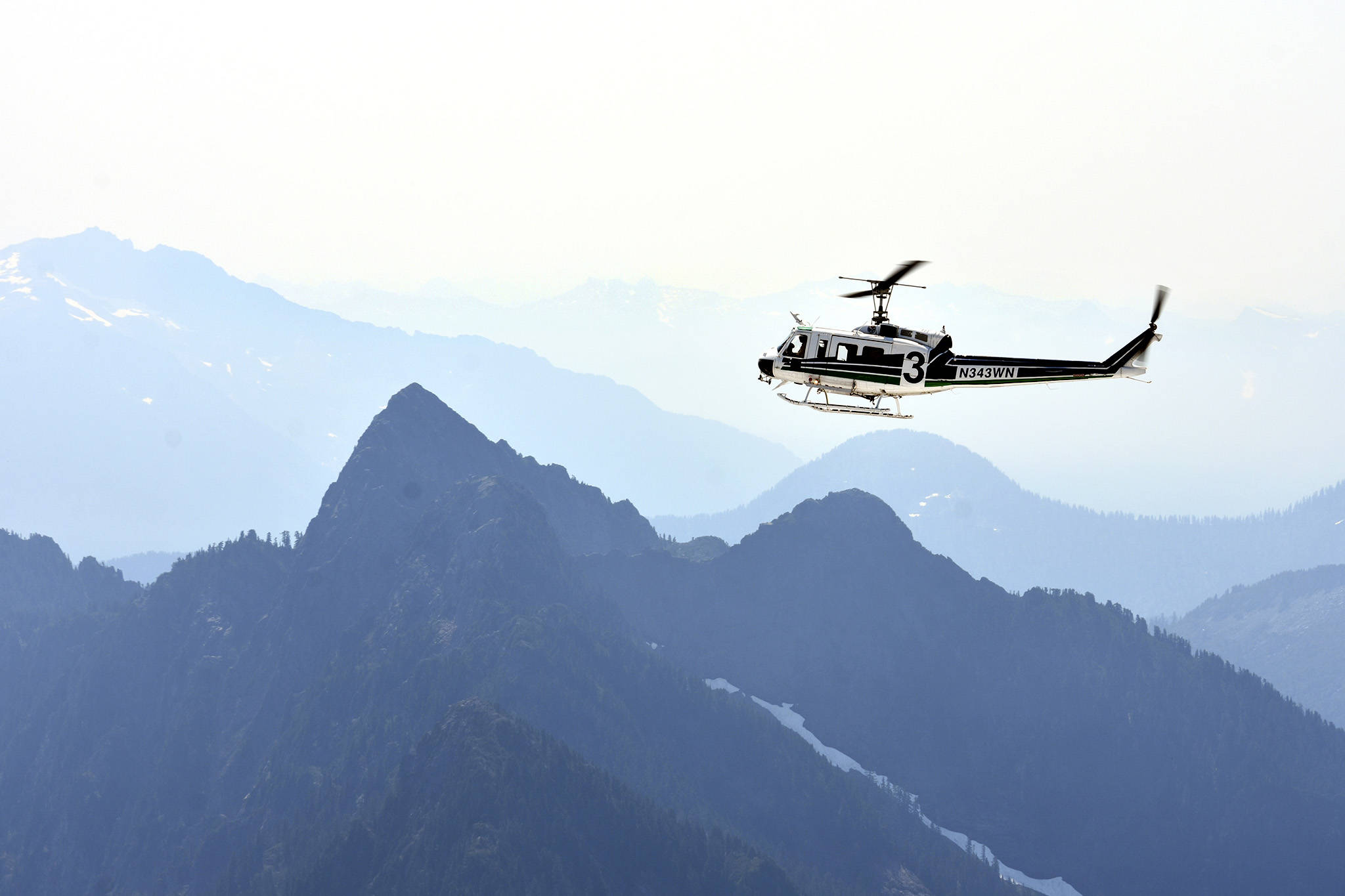 A helicopter crew scours rough terrain Sunday, Aug. 5, at Vesper Peak, in the search for missing hiker Sam Sayers, of Seattle. She went missing Aug. 1, on the hike about 30 miles east of Granite Falls. (Caleb Hutton / The Herald)