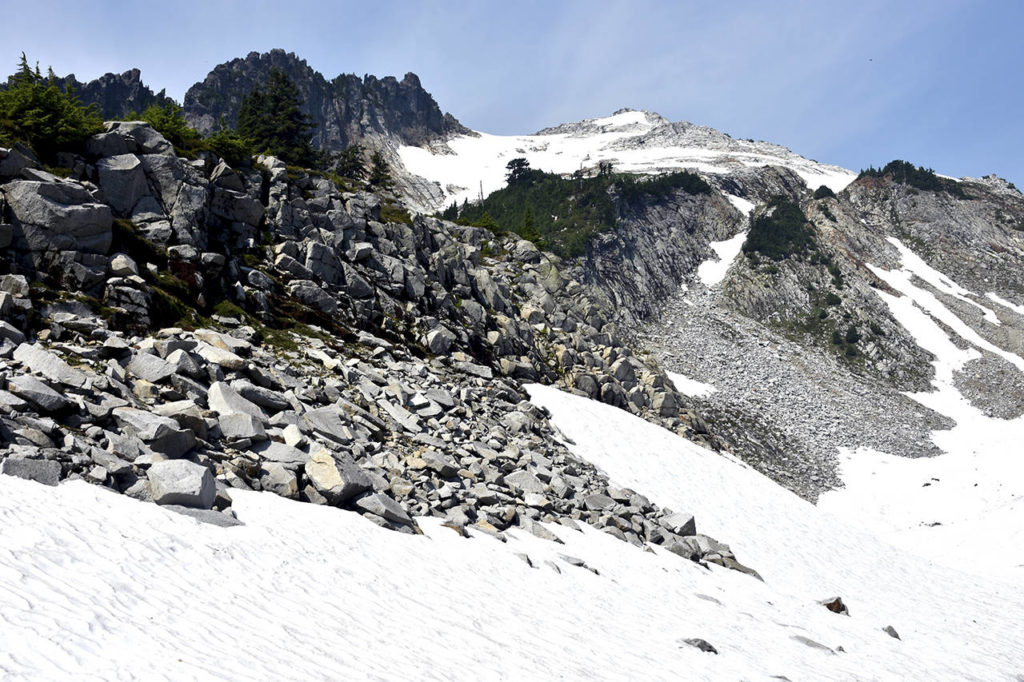 A view from the stream outlet of Vesper Lake shows snow conditions on the mountain Sunday, Aug 5, days after hiker Sam Sayers went missing. The pinnacle on the right is Vesper Peak. (Caleb Hutton / The Herald)
