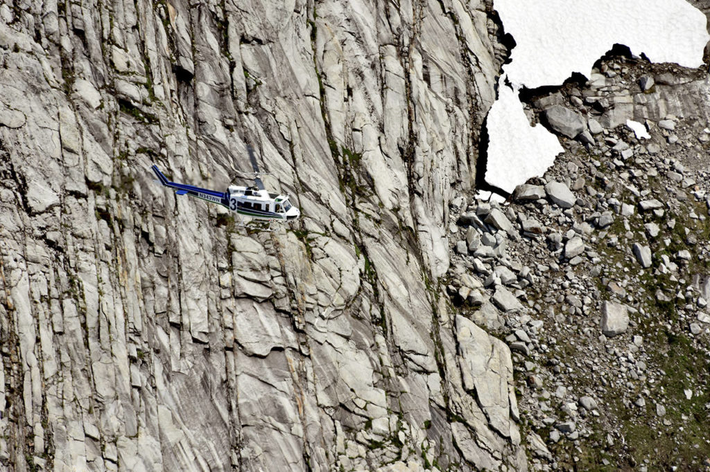 A helicopter crew scours rough terrain Sunday, Aug. 5, at Vesper Peak, in the search for missing hiker Sam Sayers, of Seattle. She went missing Aug. 1, on the hike about 30 miles east of Granite Falls. (Caleb Hutton / The Herald)
