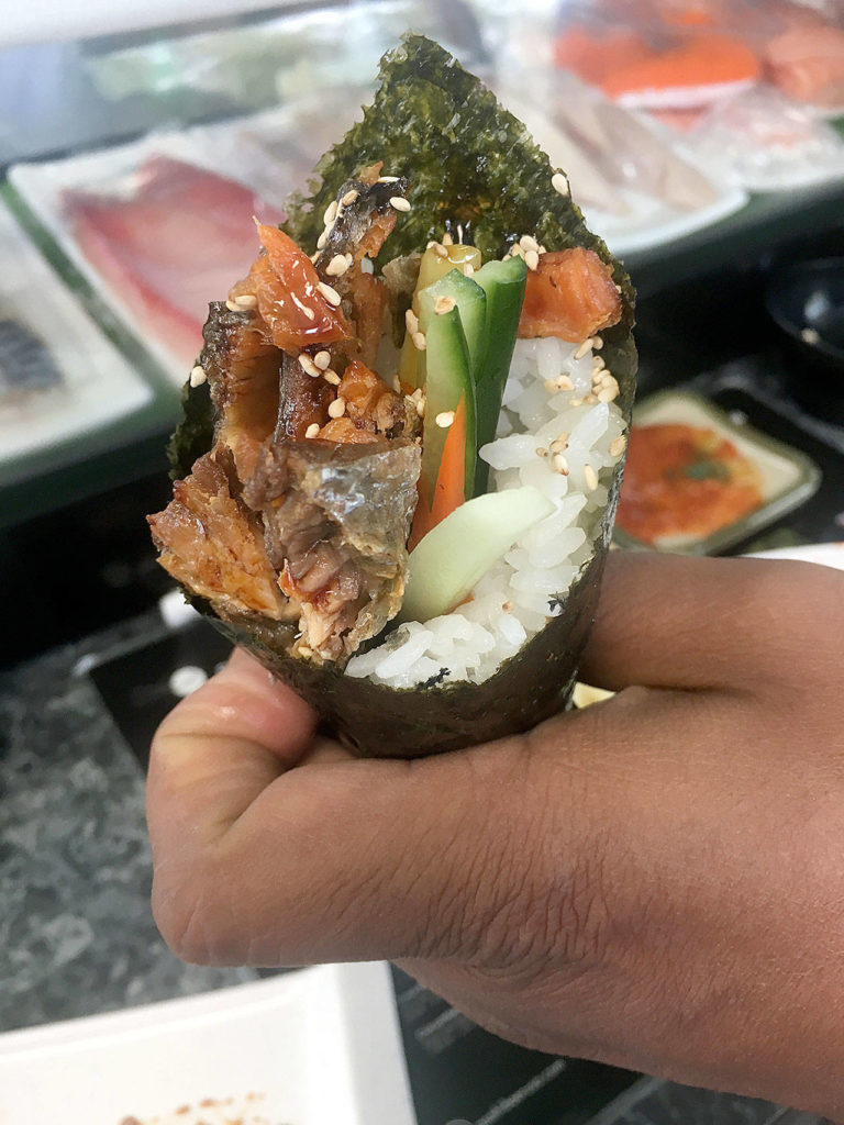 The salmon skin hand roll features twice crisped salmon skin, rice, and carrot and cucumber spears inside a seaweed handle at Sushi Ring. (Ben Watanabe / The Herald)
