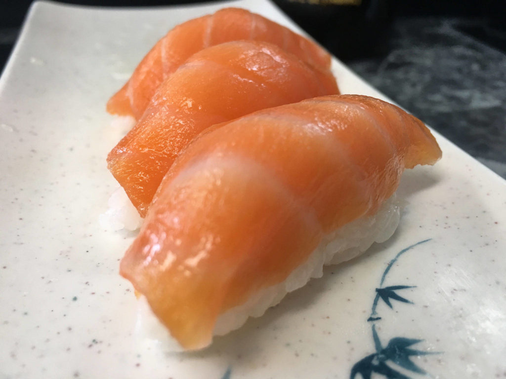 Adding some squeezed lemon on top of the smoked salmon nigiri helps brighten the briny salmon flavor at Sushi Ring. Another way of getting the citrus accent is asking for thin sliced lemon on top. (Ben Watanabe / The Herald)
