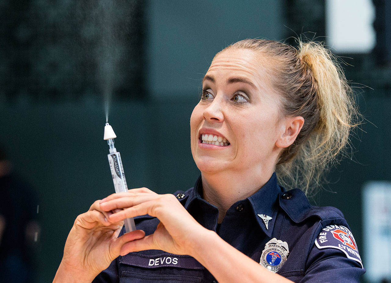 Lynnwood firefighter/paramedic Dani DeVos reacts Friday as she teaches staff of Edmonds School District how to administer Narcan via an intranasal device during ACT Training at Edmonds-Woodway High School. (Andy Bronson / The Herald)
