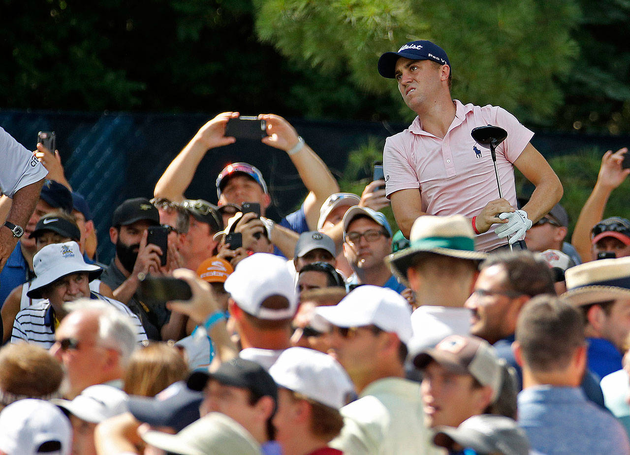 Justin Thomas watches his tee shot on the 15th hole among a crowd of fans during a practice round for the PGA Championship on Wednesday at Bellerive Country Club in St. Louis. (AP Photo/Charlie Riedel)