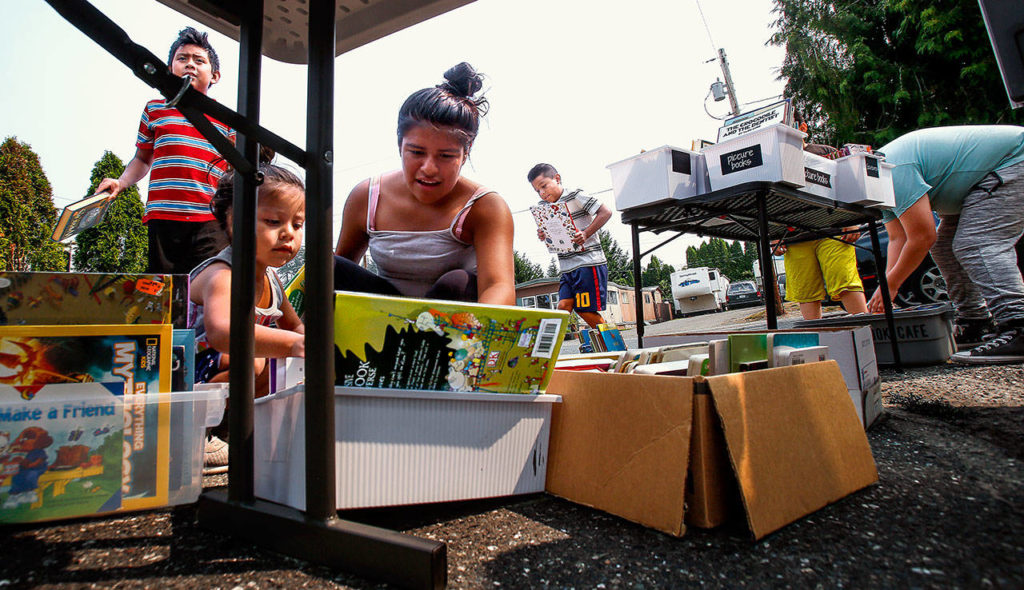 Children large and small came from every direction of the Snohomish Mobile Home Park Tuesday, when the Book Cafe showed up. (Dan Bates / The Herald)
