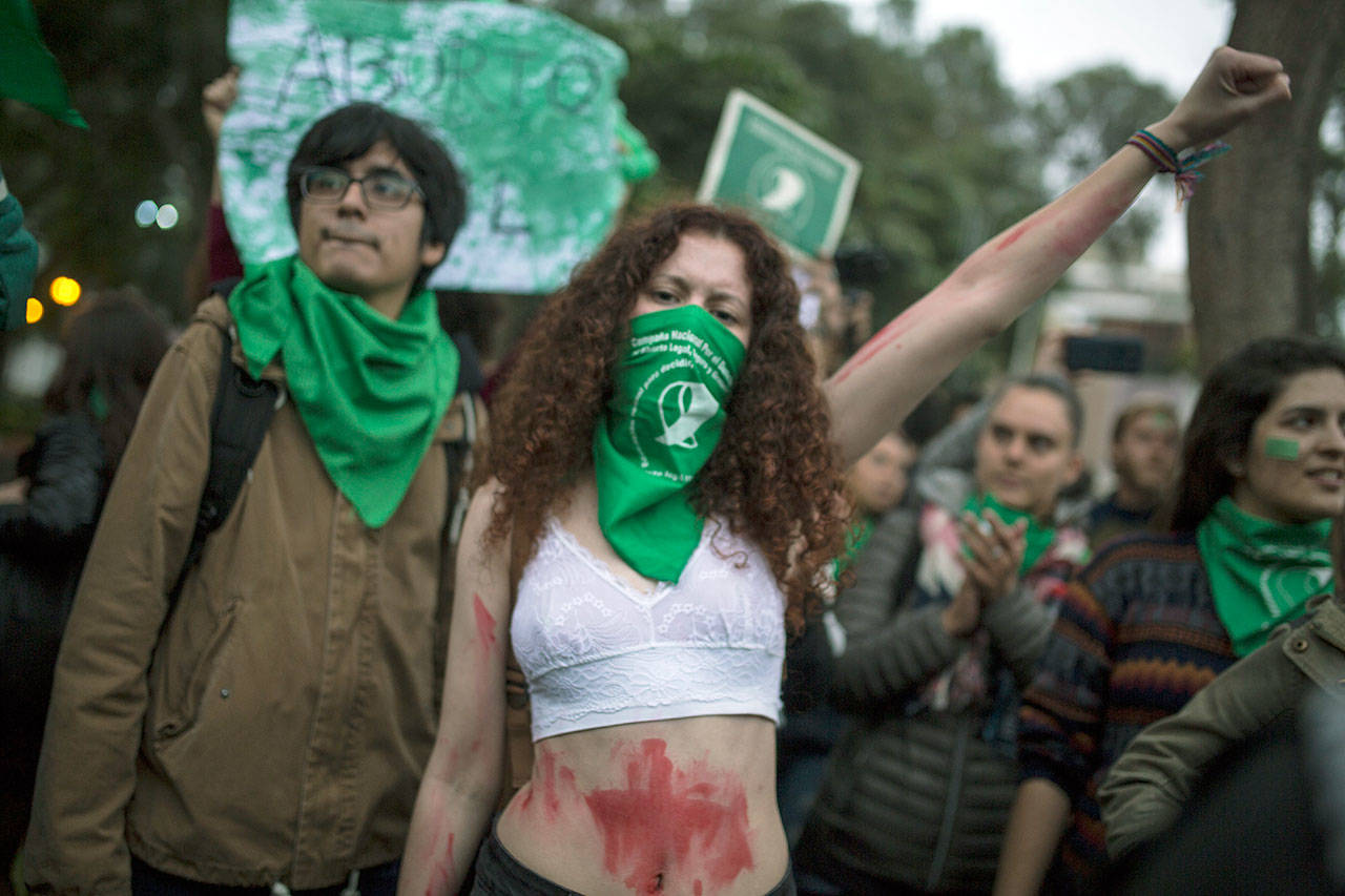 A woman raises her fist during a demonstration Wednesday in front of the Argentine embassy in Lima, Peru, to show support for the legalization of abortion in Argentina. (AP Photo/Rodrigo Abd)