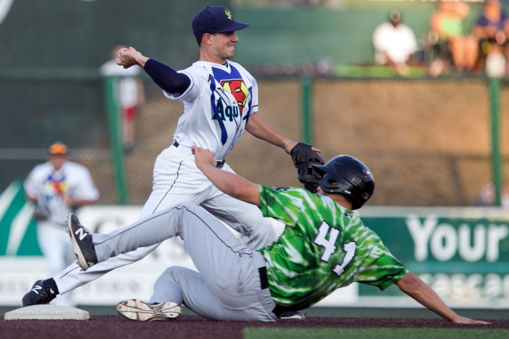 AquaSox’s Ryne Ogren tags out Emerald’s Jake Slaughter on Friday night at Everett Memorial Stadium in Everett on Aug. 10, 2018. (Kevin Clark / The Herald)
