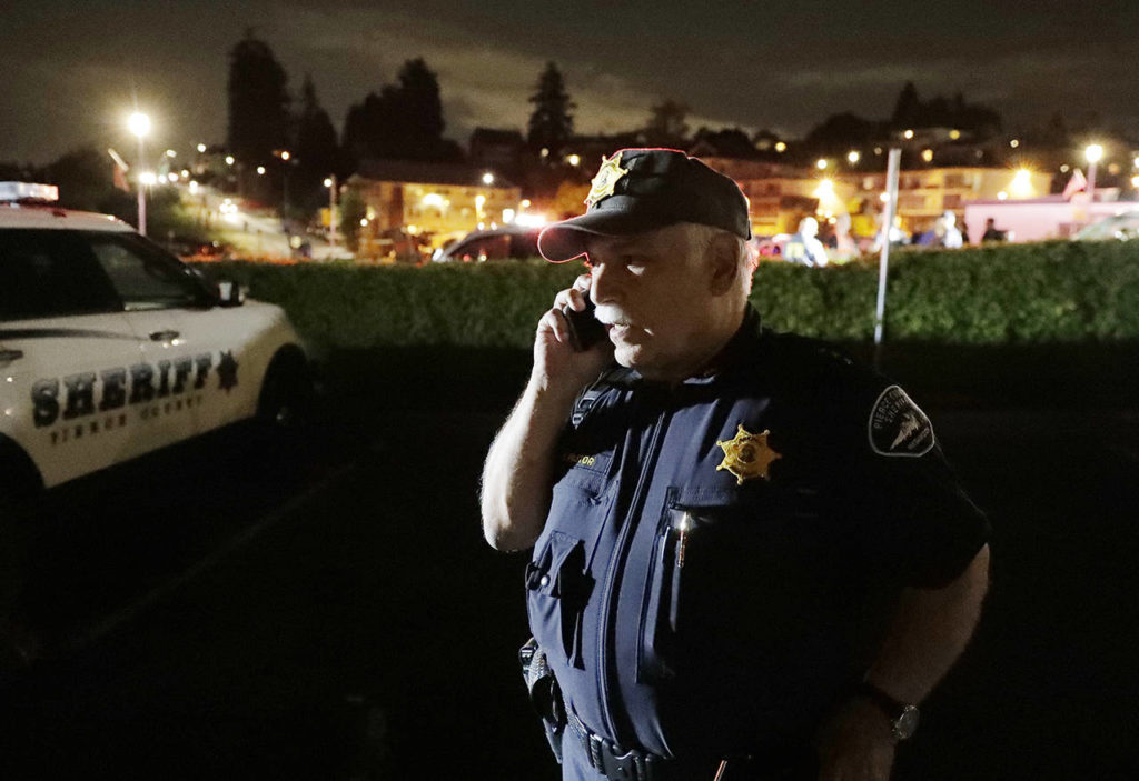 Pierce County Sheriff Paul Pastor talks on his phone at a staging area Friday at the ferry terminal in Steilacoom, near where a Coast Guard spokeswoman said the agency was responding to a report of a smoke plume and possible plane crash. (AP Photo/Ted S. Warren)
