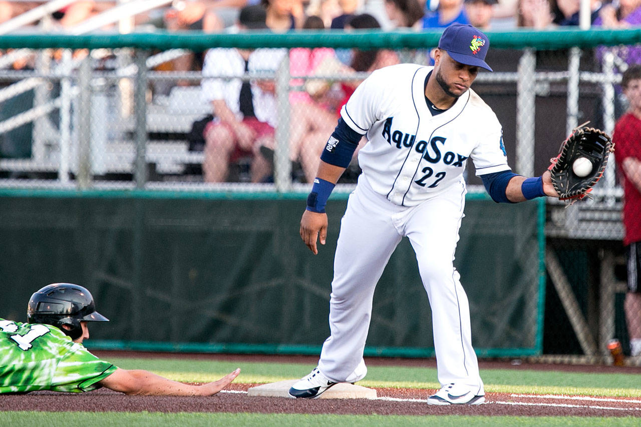 Robinson Cano, playing for the Everett AquaSox on Aug. 9, catches a pickoff throw at first base as Eugene’s Jake Slaughter slides in safely at Everett Memorial Stadium. Cano is eligible to return to the Mariners on Tuesday. (Kevin Clark / The Herald)