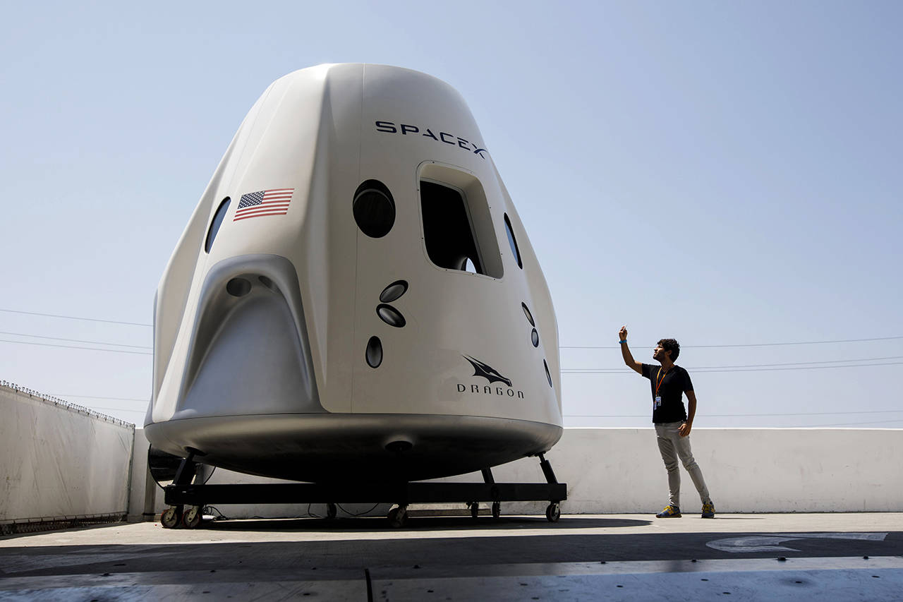 An attendee photographs a mockup of the Crew Dragon spacecraft ahead of the NASA Commercial Crew Program astronaut visit at the Space Exploration Technologies Corp. headquarters in Hawthorne, California, on Aug. 13. (Patrick T. Fallon/Bloomberg)