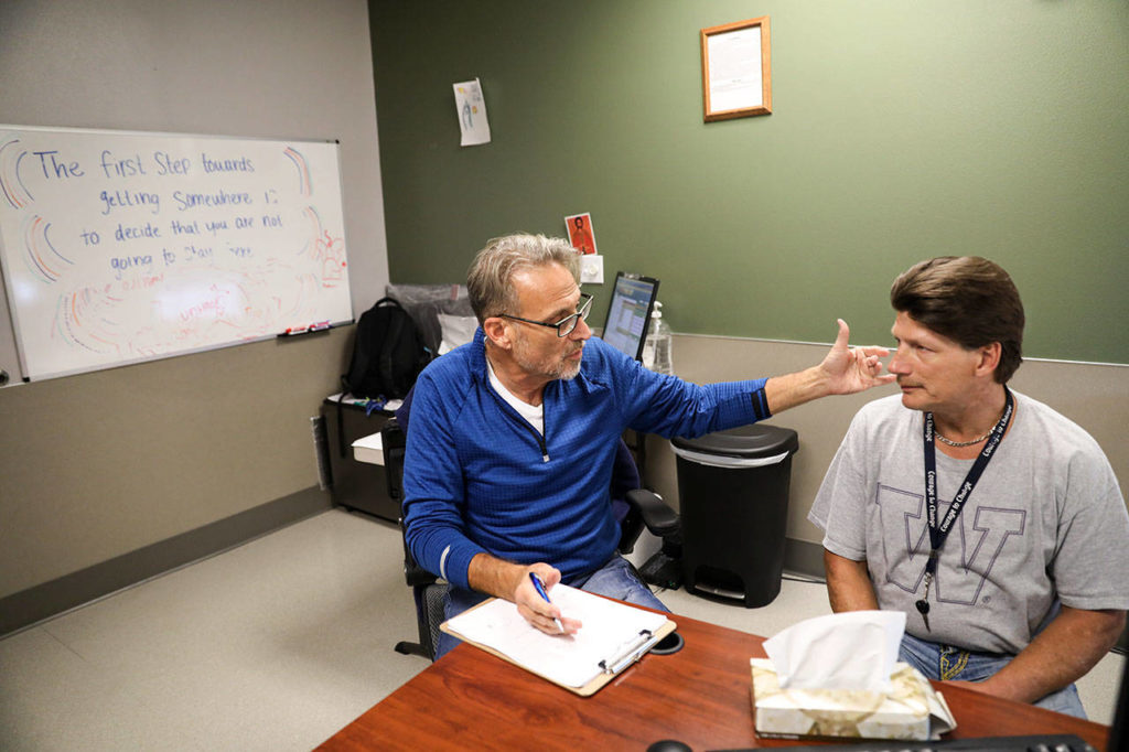 Geoff Godfrey, (left) a nurse practitioner at Ideal Option, talks with Curtis Letzkus (right) about his treatment plan. (Lizz Giordano / The Herald)
