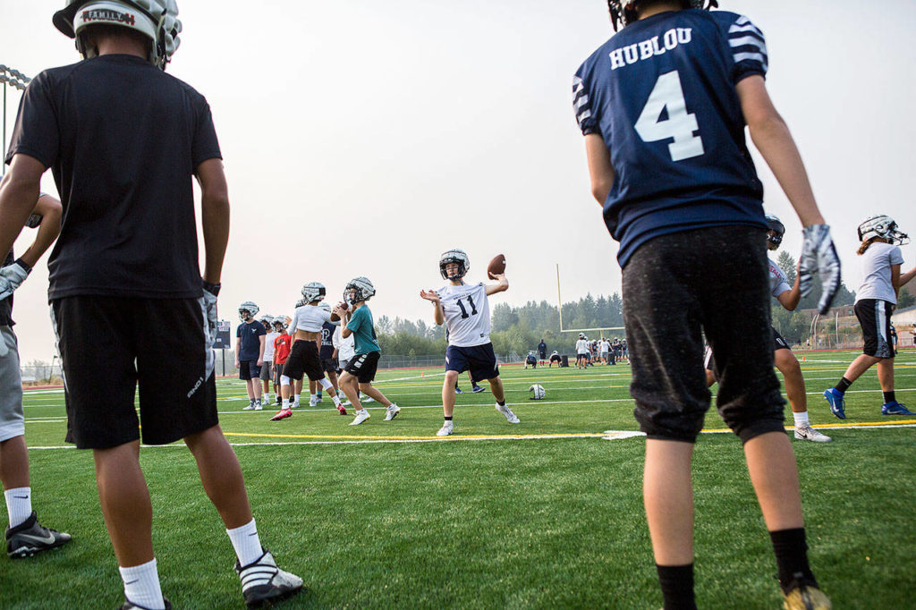 Jadon Claps, center, throws the ball during football practice at Glacier Peak High School on Aug. 15, 2018 in Snohomish, Wa. (Olivia Vanni / The Herald)
