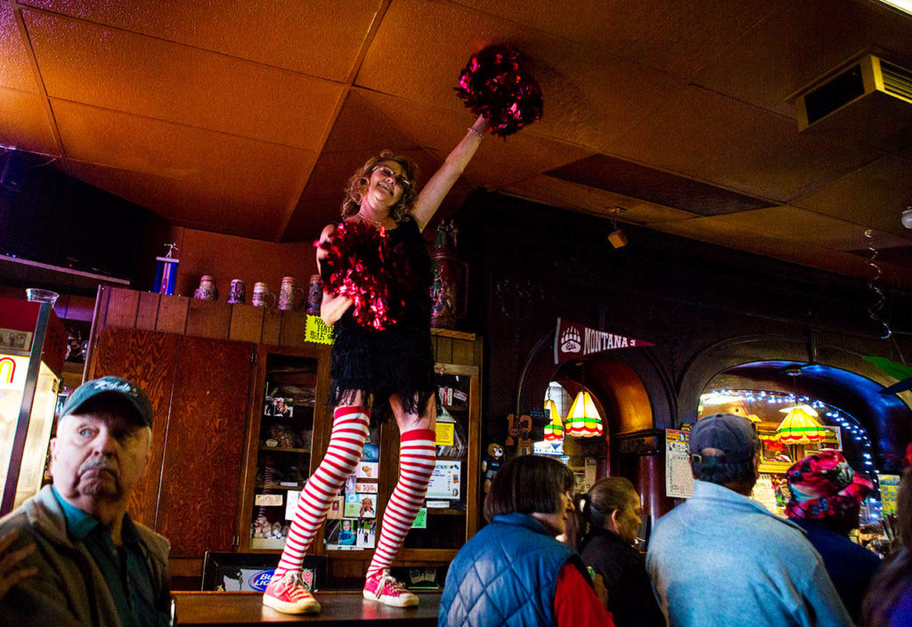 Tanya Buttke dances on the bar during the Kuhnle’s Tavern 100th year celebration Saturday in Marysville. (Olivia Vanni / The Herald) 
