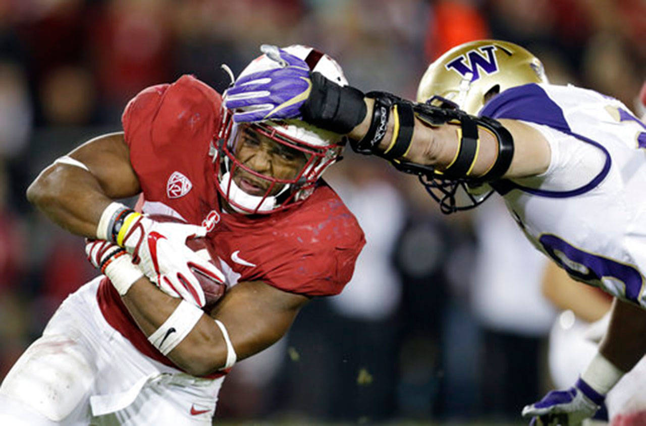 Washington linebacker Connor O’Brien (right) attempts to tackle Stanford running back Bryce Love during a game last November. Both Love and the Huskies are facing high expectations this season. (AP Photo/Marcio Jose Sanchez, File)