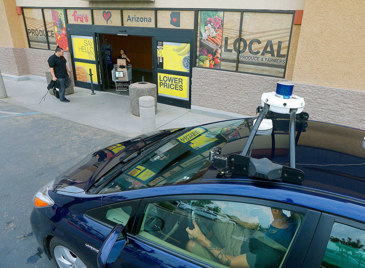 A self-driving Nuro vehicle parks Thursday in Scottsdale, Arizona, outside a Fry’s supermarket, which is owned by Kroger, as part of a pilot program for grocery deliveries. The Toyota Prius will be used for the deliveries, manned by a human to monitor its performance. During phase two in the fall, deliveries will be made by a completely autonomous vehicle, called an R1, with no human aboard. (AP Photo/Ross D. Franklin)