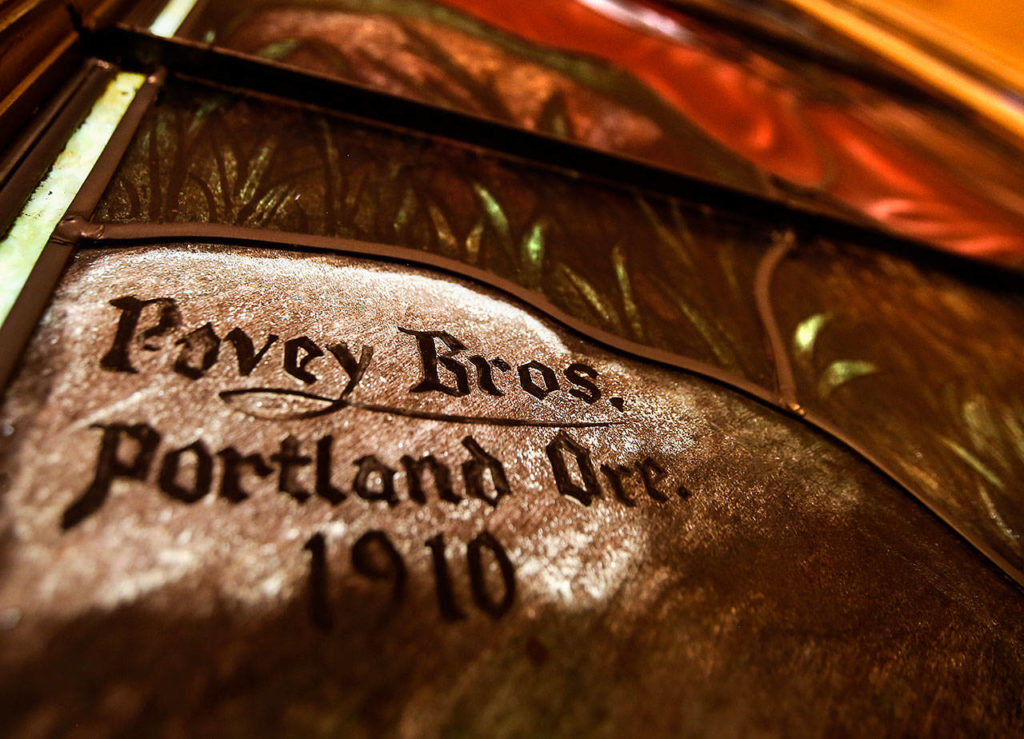 In a corner of the large stained glass window facing east at the First Presbyterian Church in Everett is the Povey Bros., of Portland, Oregon, signature, dated 1910. The window depicts Christ teaching the “Parable of the Lily.” (Dan Bates / The Herald)
