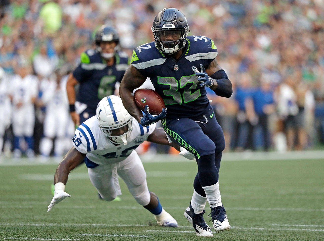 Seahawks running back Chris Carson (32) outruns a tackle attempt by Colts linebacker Skai Moore during the first half of a preseason game on Aug. 9, 2018, in Seattle. (AP Photo/Elaine Thompson)