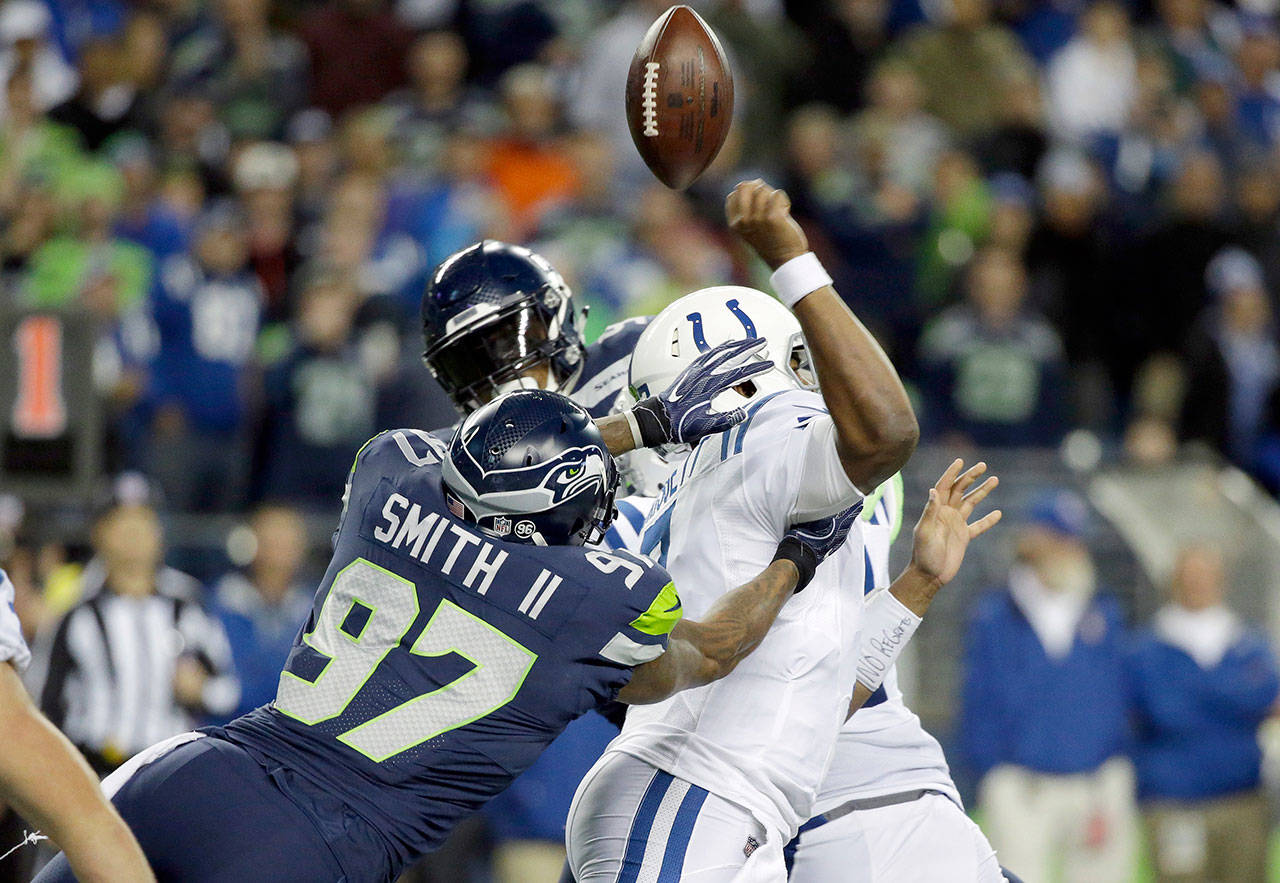 Seattle’s Marcus Smith (97) forces a fumble by Indianapolis’ Jacoby Brissett that was recovered by Bobby Wagner for a touchdown during an Oct. 1, 2017 game in Seattle. The Seahawks released Smith on Friday. (AP Photo/Elaine Thompson)