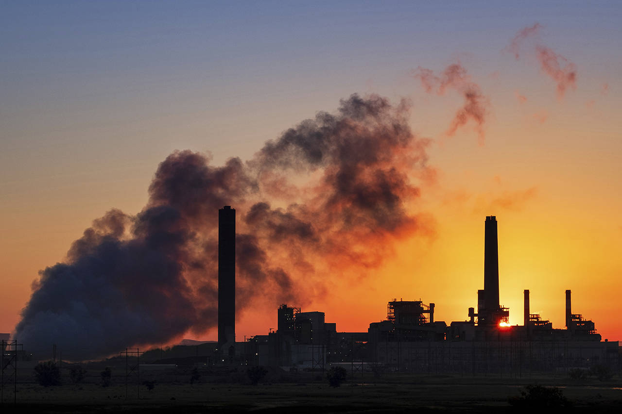In this July 27 photo, the Dave Johnson coal-fired power plant is silhouetted against the morning sun in Glenrock, Wyoming. (AP Photo/J. David Ake)