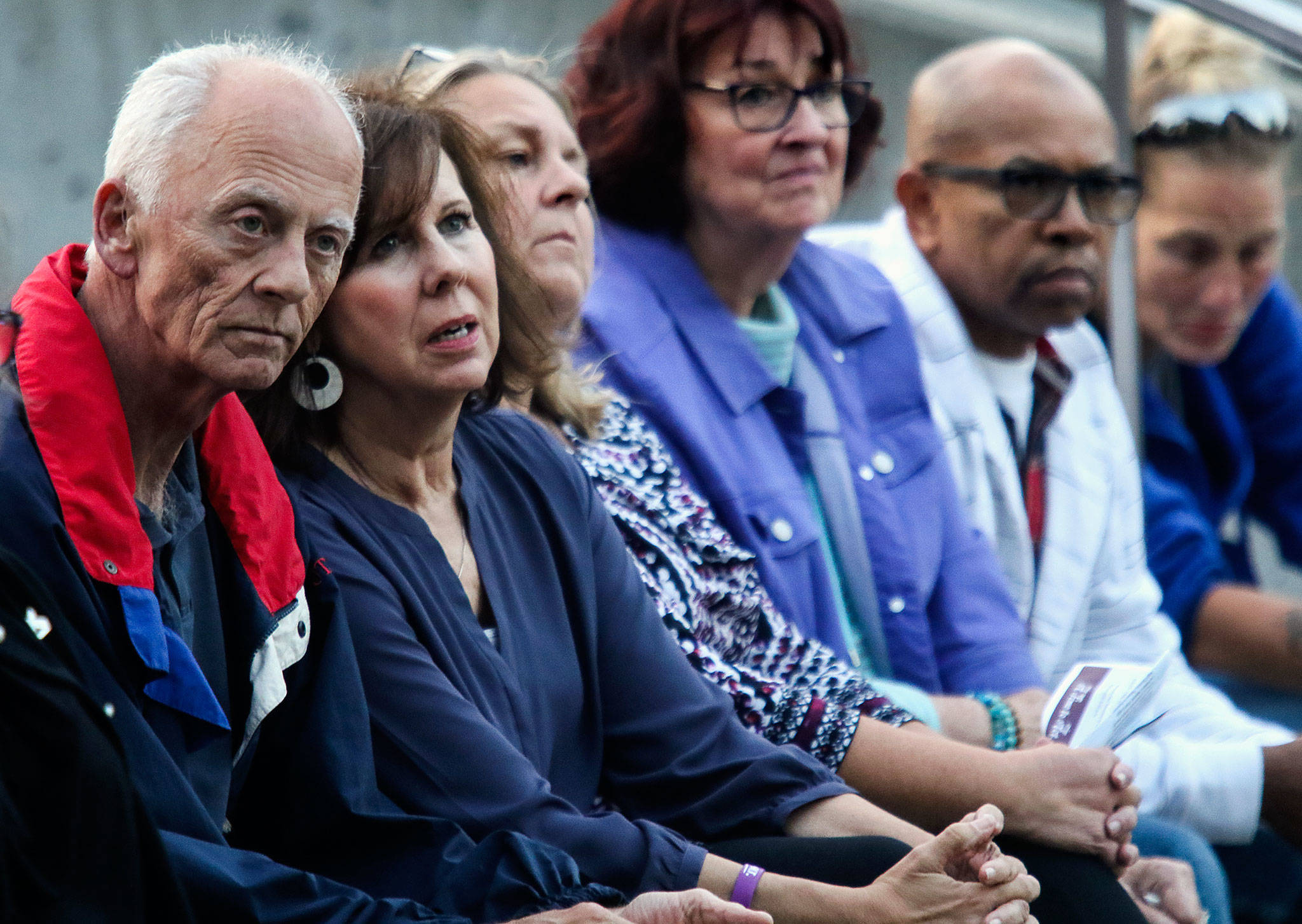 Mike and Debbie Warfield (left), who lost their 24-year-old son Spencer to a heroin overdose, listen with others to speakers at “A Night to Remember, A Time to Act.” The event, Thursday night at the courhouse plaza, drew attention to the opioid crisis. (Dan Bates / The Herald)