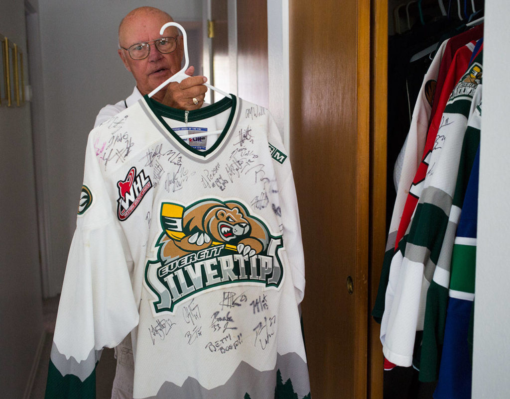 Parker Fowlds, who has been a Silvertips billet since the franchise began in 2003, holds up a team-signed jersey on Aug. 17 in his Mukilteo home. (Andy Bronson / The Herald)
