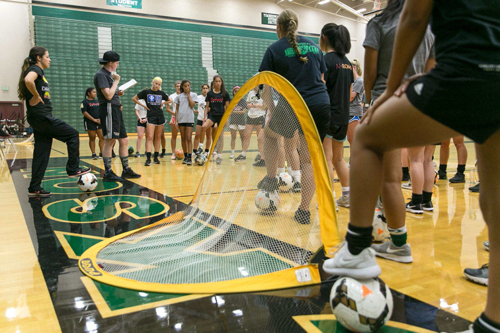 Students gather to hear their assigned basketball court to tryout for the soccer teams in the gym at Jackson High School due to poor air quality in Mill Creek on August 21, 2018. (Kevin Clark / The Herald)
