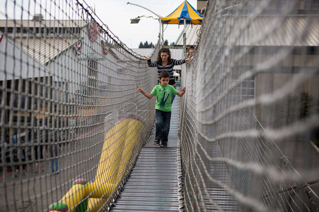 Drayden Sharpe, 5, holds onto the rope fence as he walks through an obstacle course during the Morning of Dreams at the Evergreen State Fair on Wednesday in Monroe. (Olivia Vanni / The Herald)
