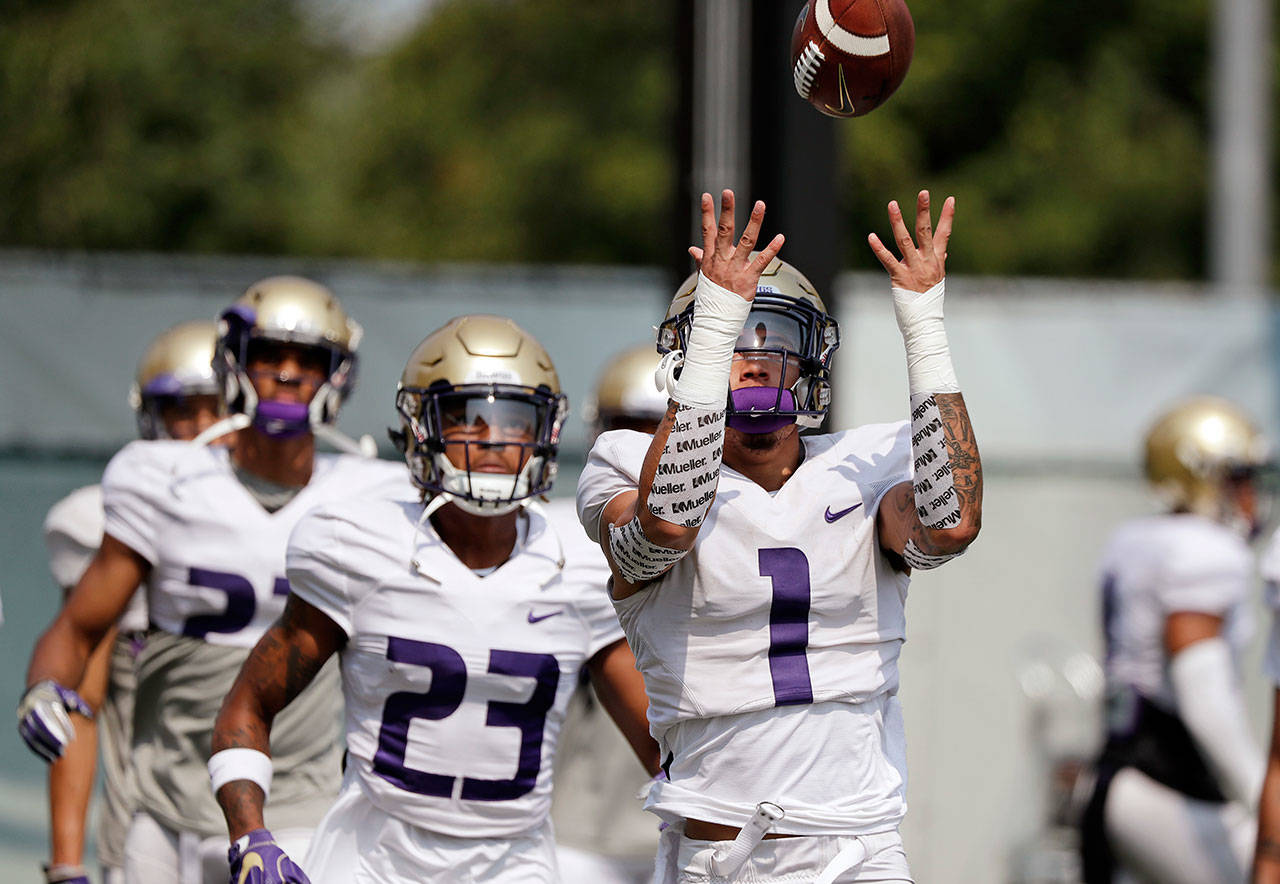 Washington’s Byron Murphy (1) reaches for a ball as Jordan Miller (23) looks on during a practice on Aug. 10, 2018, in Seattle. (AP Photo/Elaine Thompson)
