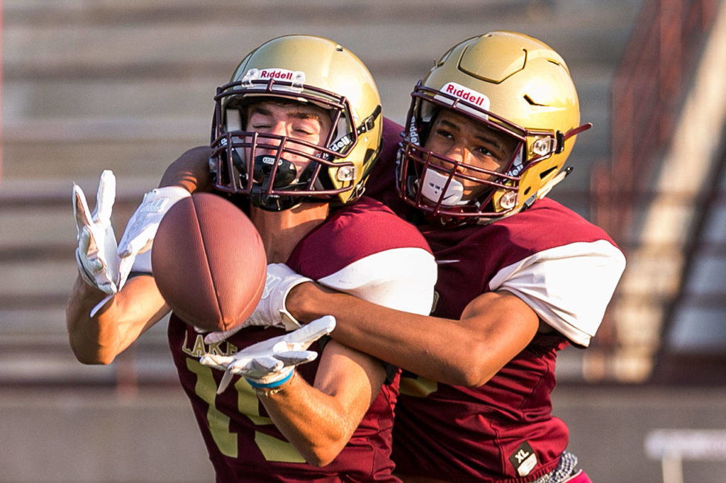 Lakewood’s Cobe Matthews (left) attempts a catch with Aquarius Sherrod defending during practice on Aug. 23, 2018, at Lakewood High School in Arlington. (Kevin Clark / The Herald)
