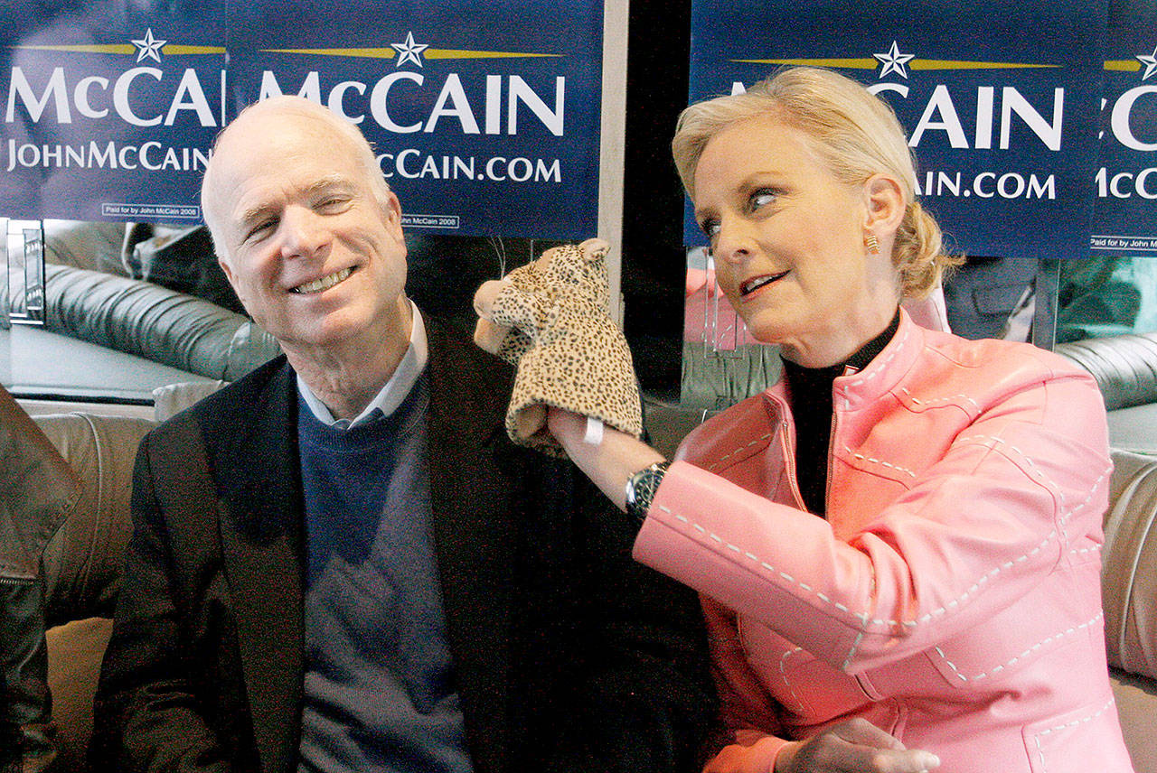 Cindy McCain (left), wife of then-presidential hopeful Sen. John McCain, used a cheetah hand puppet to make her husband laugh in 2008 as they rode the “Straight Talk Express” campaign bus. (AP Photo/Charles Dharapak, File)