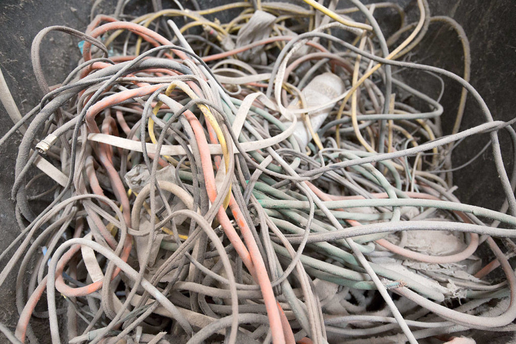 Wires that can tangle up machinery are one of the first things that sorters take out at Waste Management’s recycling center Tuesday in Woodinville. (Andy Bronson / The Herald)
