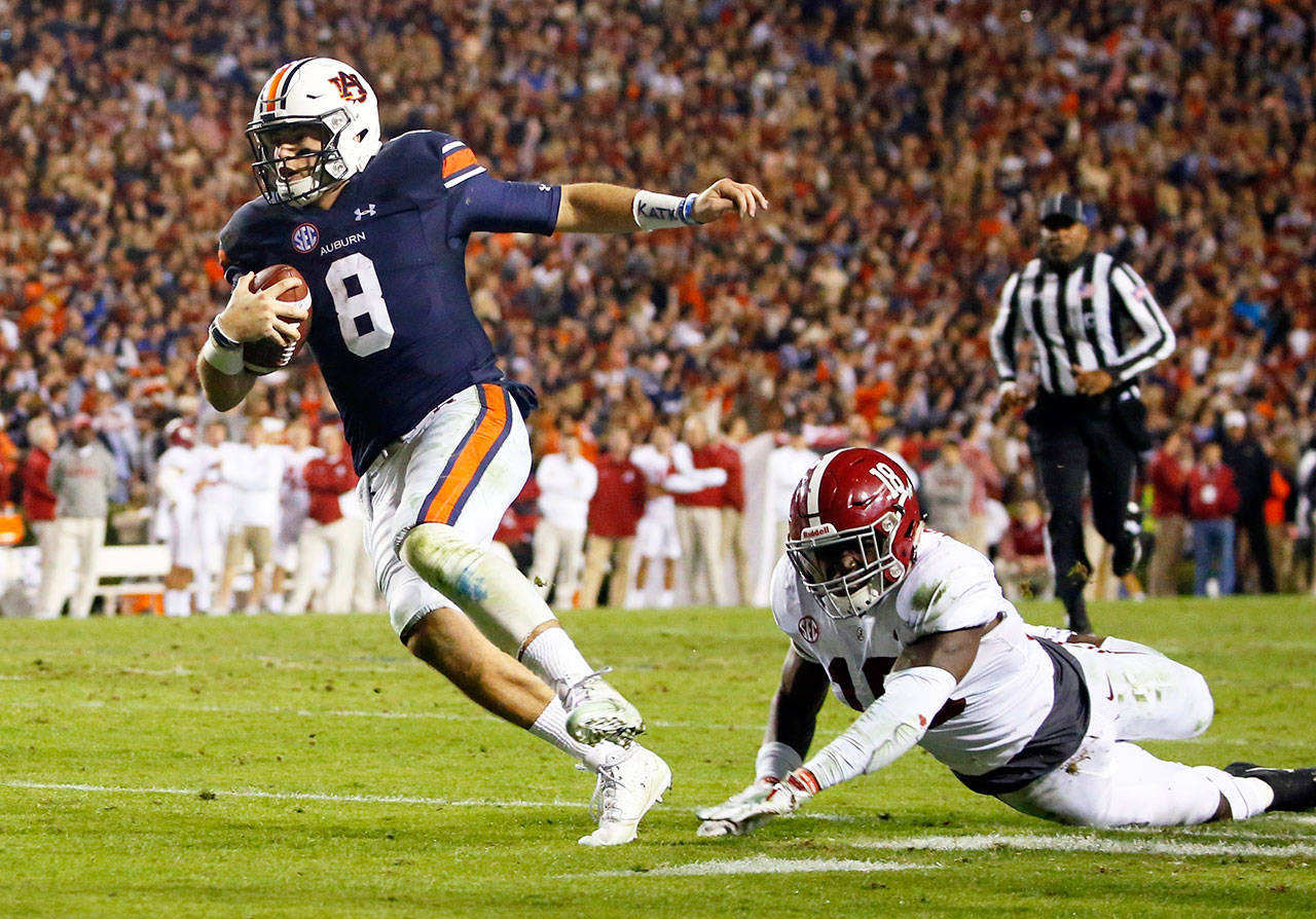 Auburn quarterback Jarrett Stidham (8) scampers past Alabama linebacker Dylan Moses (18) and into the end zone during the Iron Bowl NCAA in Auburn, Ala. on Nov. 25, 2017. (Butch Dill/ Associated Press)
