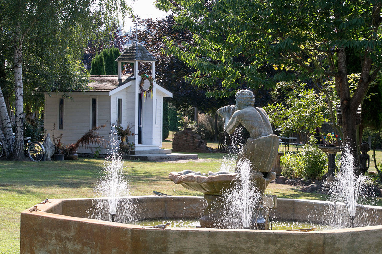 A European style fountain, multiple outbuildings and lawn sculptures dot the landscape of the old Silvana Schoolhouse. (Kevin Clark / The Herald)