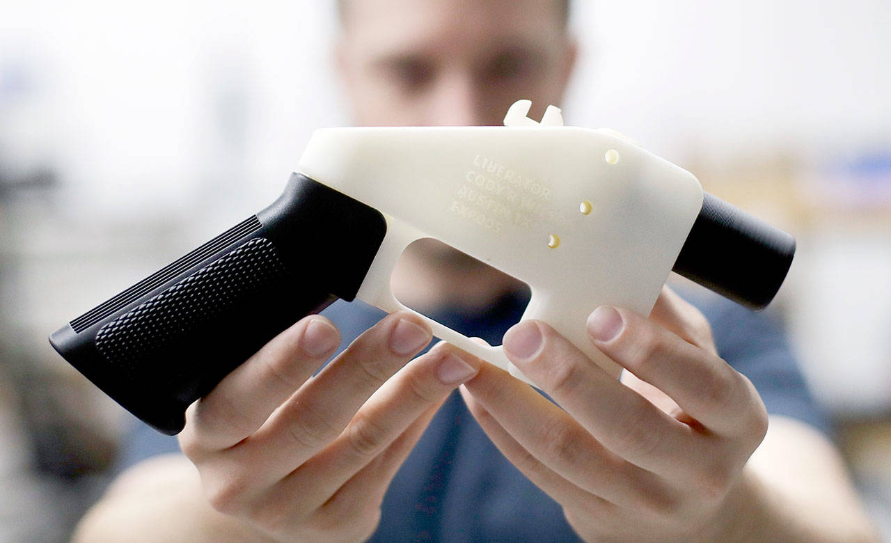 Cody Wilson, owner of Defense Distributed, holds a 3D-printed gun called the Liberator at his shop in Austin, Texas. (AP Photo/Eric Gay, file)