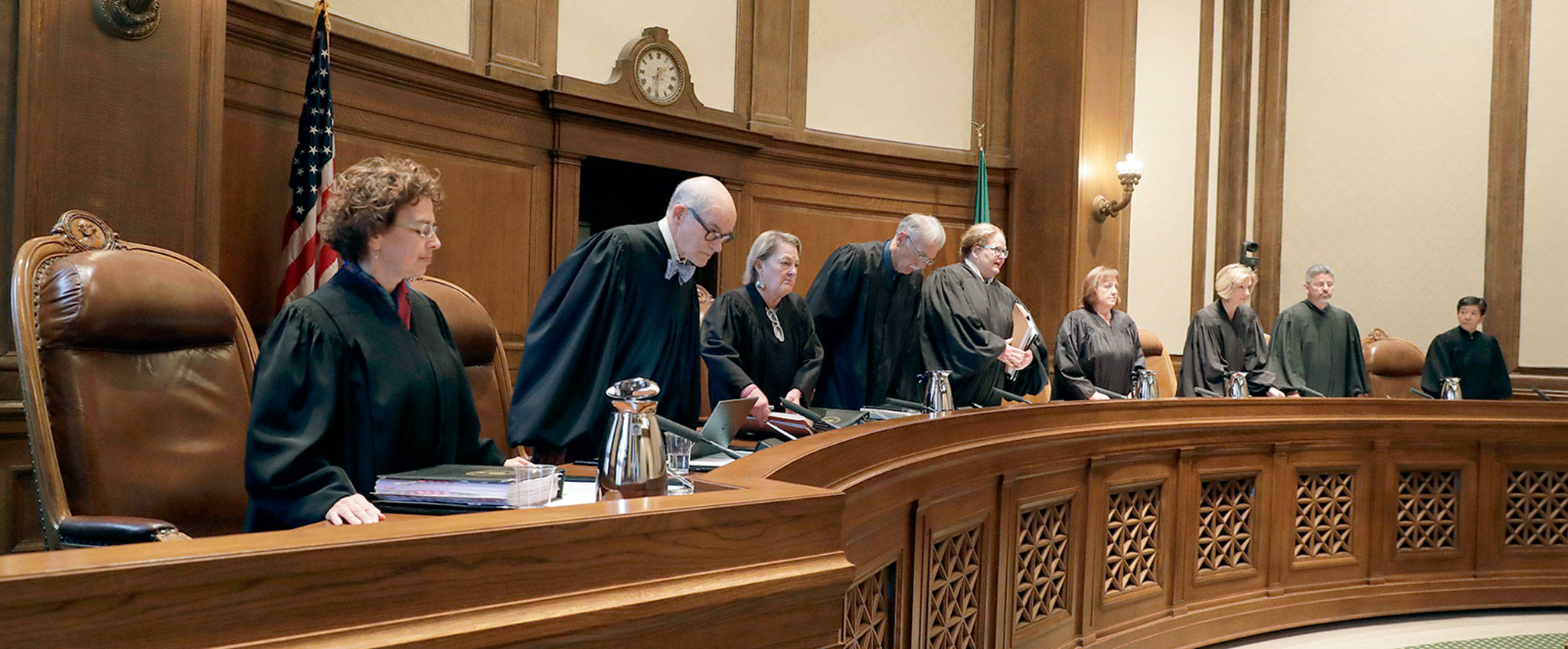 The justices of the Supreme Court of Washington take their seats June 28 at the start of a session where they heard arguments over whether state lawmakers acted constitutionally when they passed a new state law designed to improve police training and make it easier to prosecute officers for negligent shootings. (Ted S. Warren / AP file)