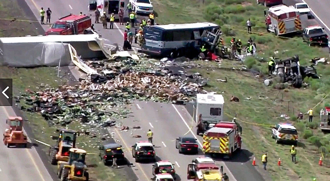 This photo from video provided by KQRENews13 shows first responders working the scene of Thursday’s deadly collision between a Greyhound passenger bus and a semi-truck on Interstate 40 near the town of Thoreau, New Mexico. At least seven people were killed and others were seriously injured. (KQRENews13 via AP)