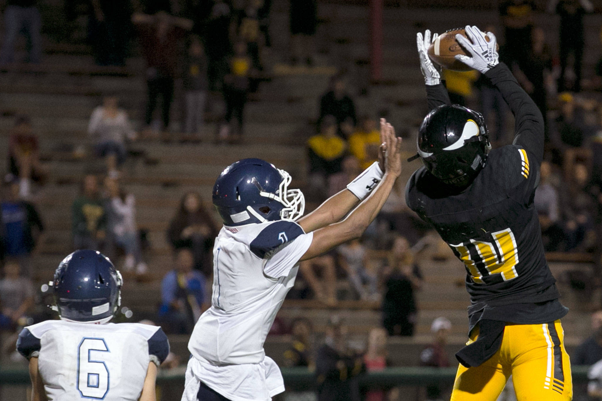 Inglemoor’s Luke Millman (right) makes the game winning touchdown setting up a two-point conversion with Meadowdale’s Jaiden McCormick (center) and Meadowdale’s Tyler Gibson (left) looking on Thursday night at Pop Kenney Stadium in Bothell on August 30, 2018. Inglemoor won 29-28. (Kevin Clark / The Herald)